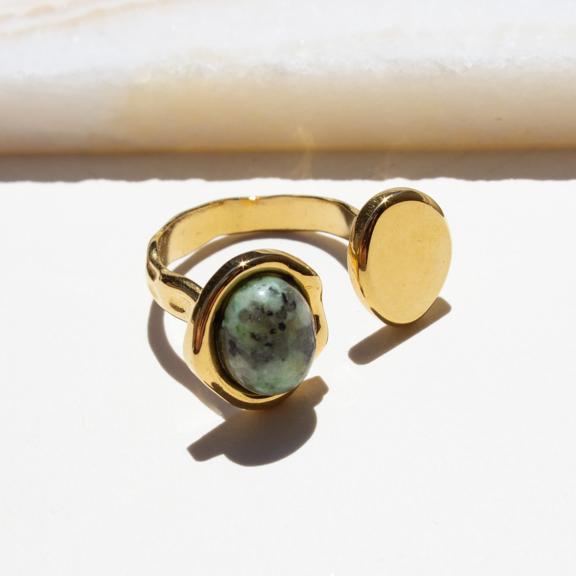 Gold ring with a african turquoise stone on a white background.