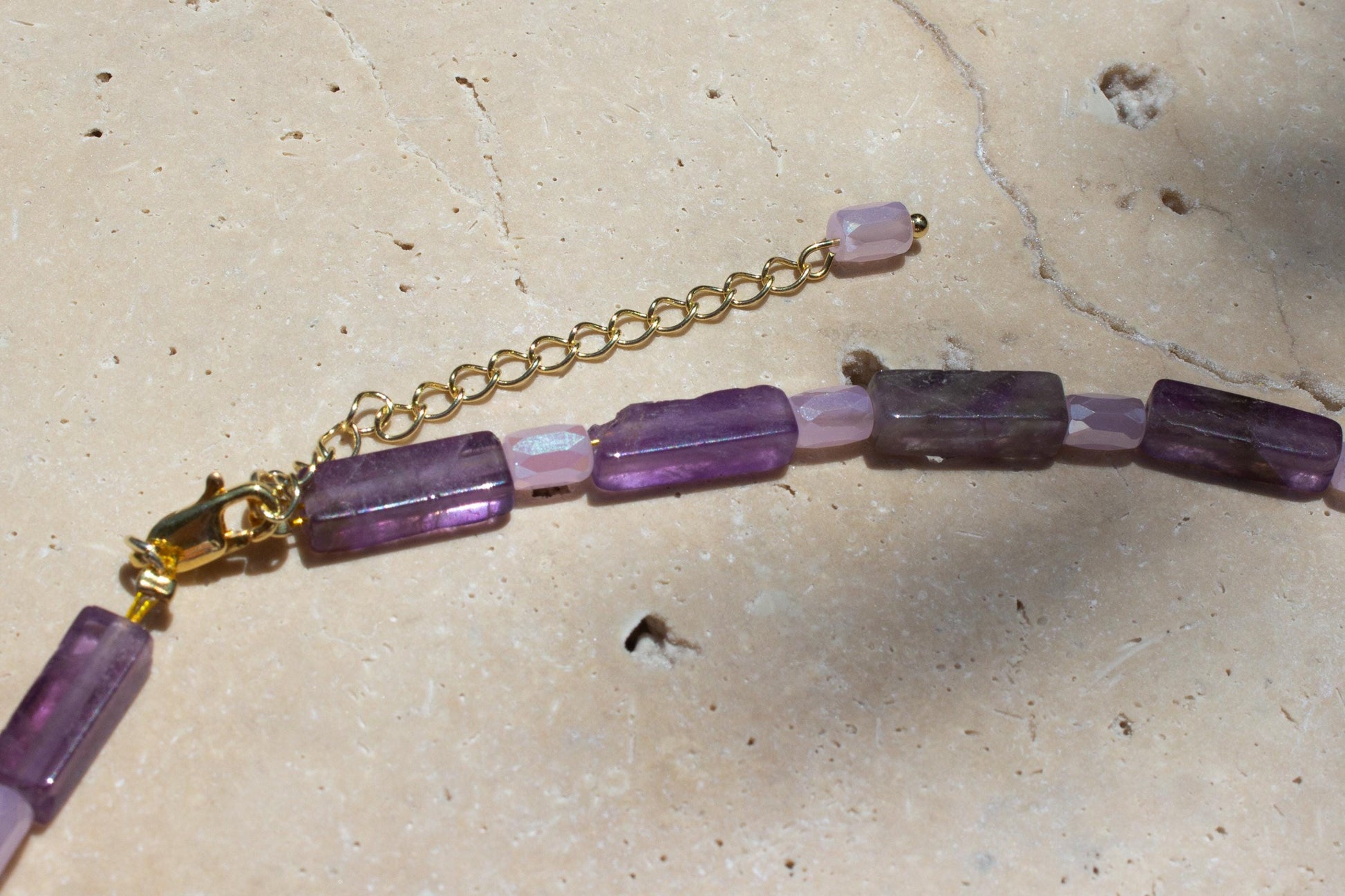 purple beaded necklace with a 2inch gold ton extender clasp.
