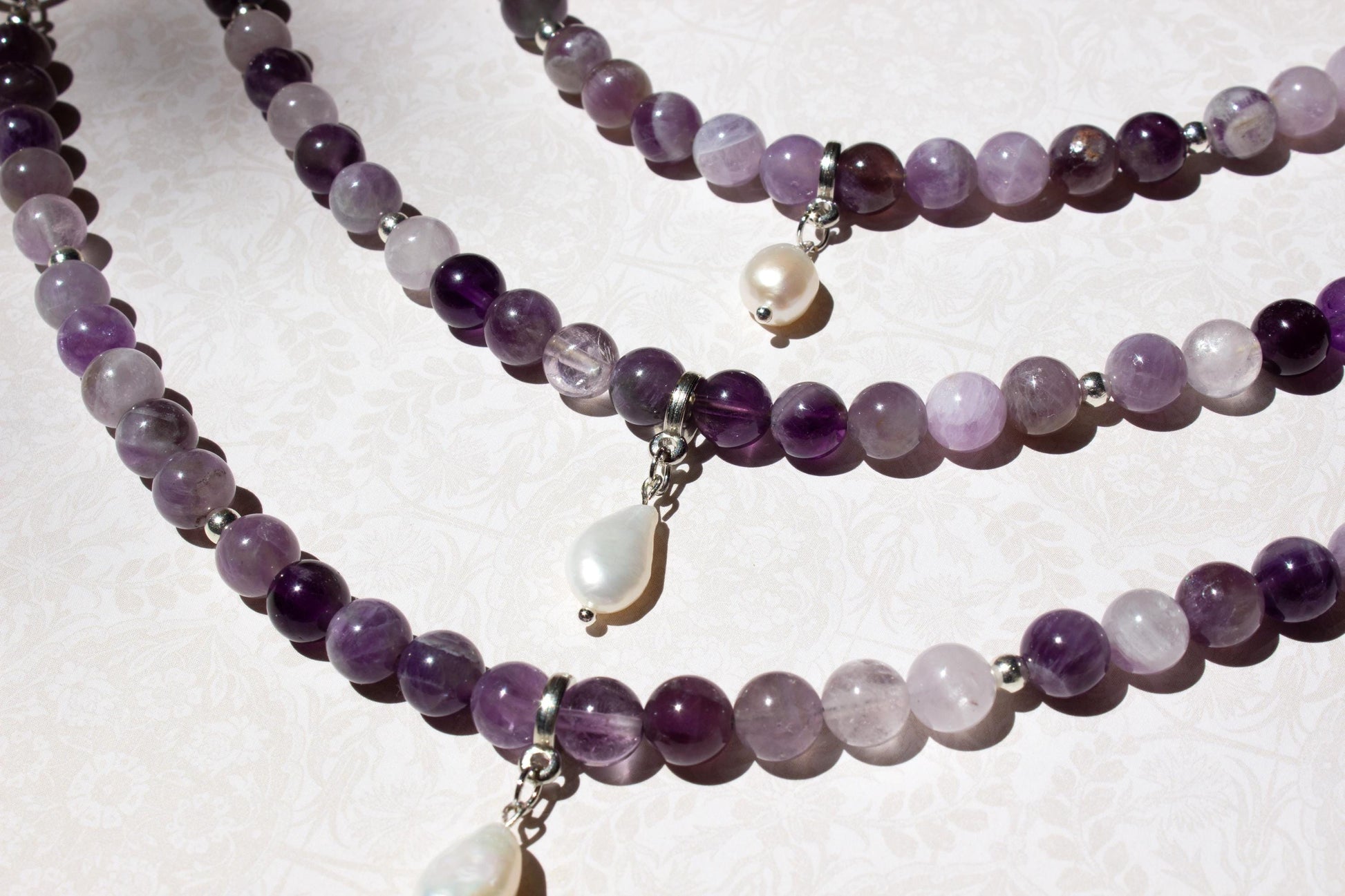 three purple bag charms with pearl.