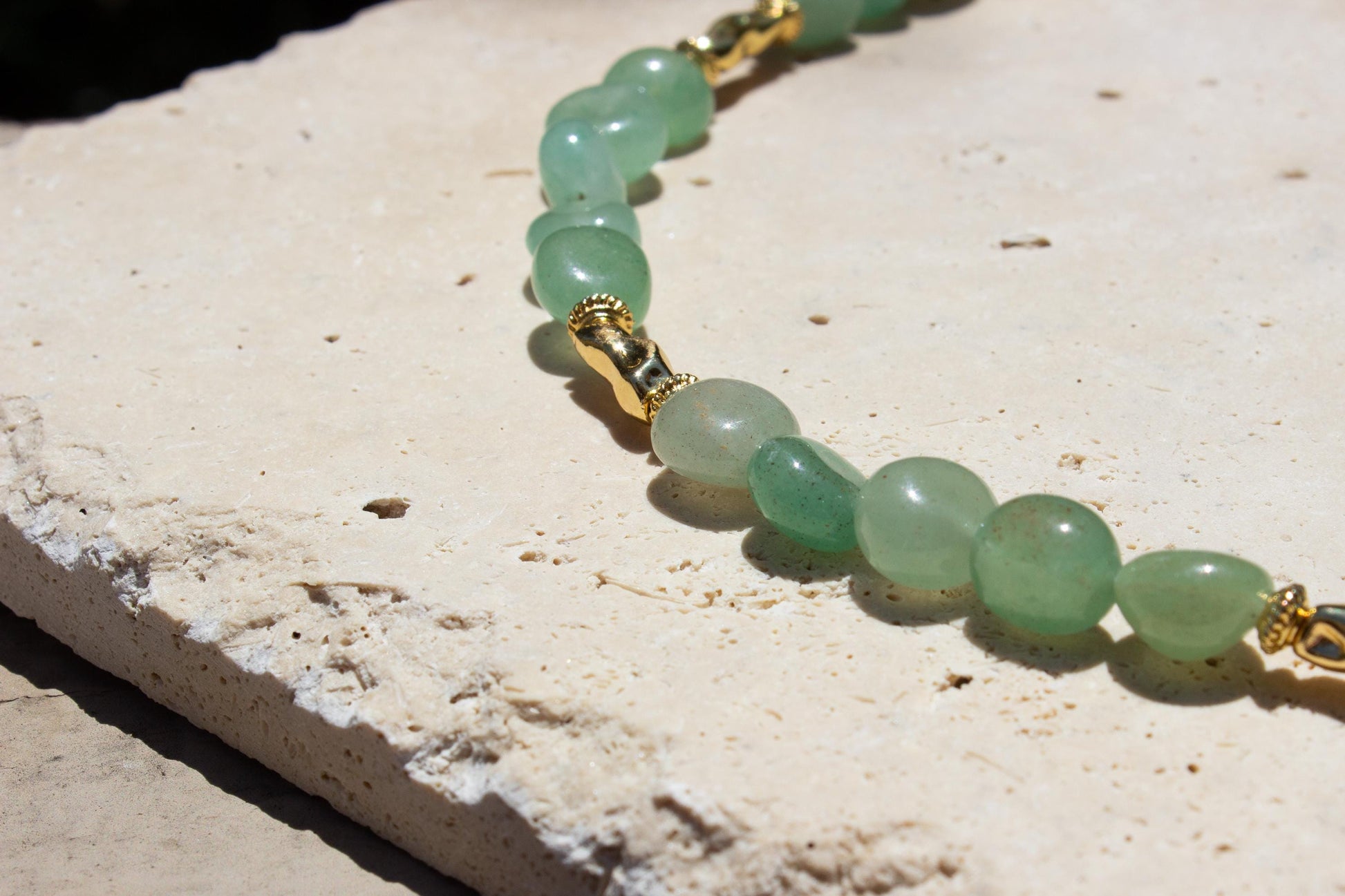 close up of green aventurine beaded necklace with gold beads.