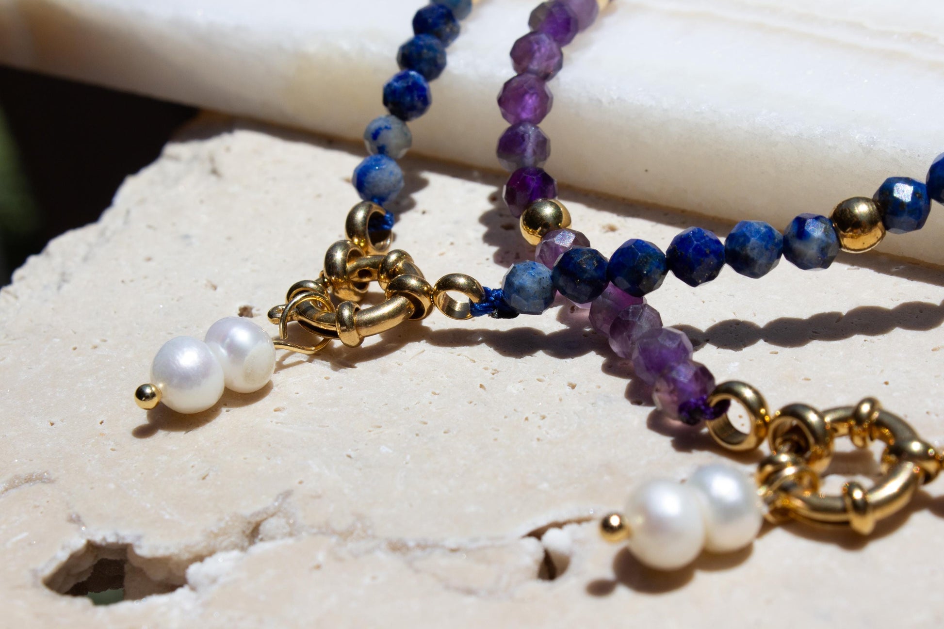 blue and purple crystal necklace in amethyst and lapis lazuli. Both necklaces have two small pearl charms.