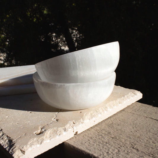 two white selenite crystal bowls stacked on top of each other.