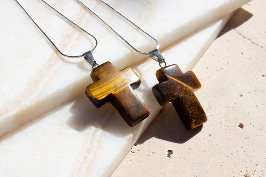 two religious cross necklaces in a bronze color. The gemstone is tigers eye.