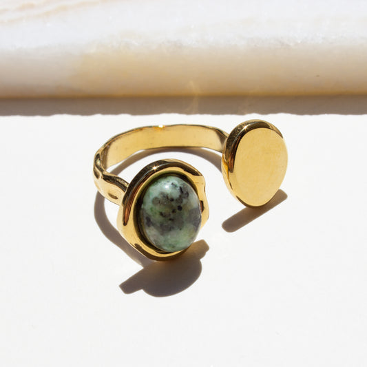 Gold ring with a african turquoise stone on a white background.