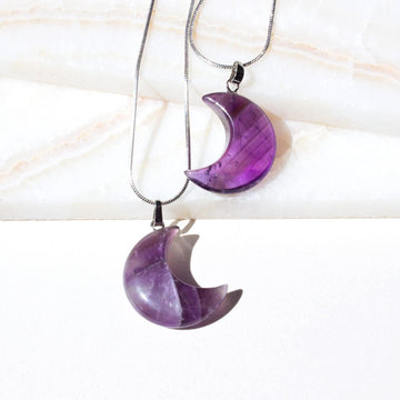 two amethyst necklaces in shape of a moon facing opposite directions 