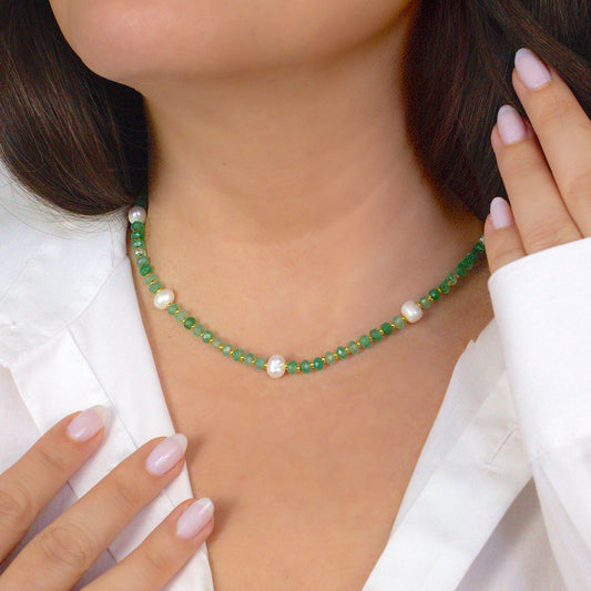 Close-up of a person wearing a green beaded necklace with white pearls. Green aventurine crystal beads with genuine pearl. 