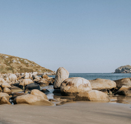 Rocks on a beach with a clear blue sky