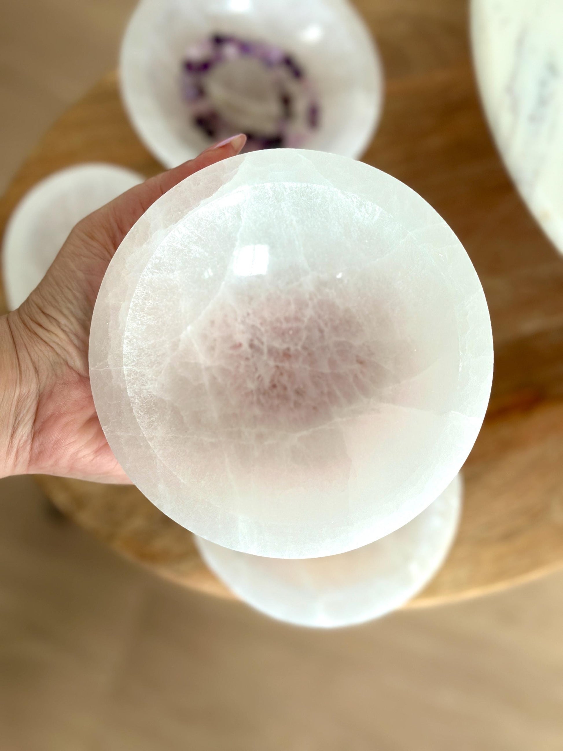 person holding a large white crystal bowl. 